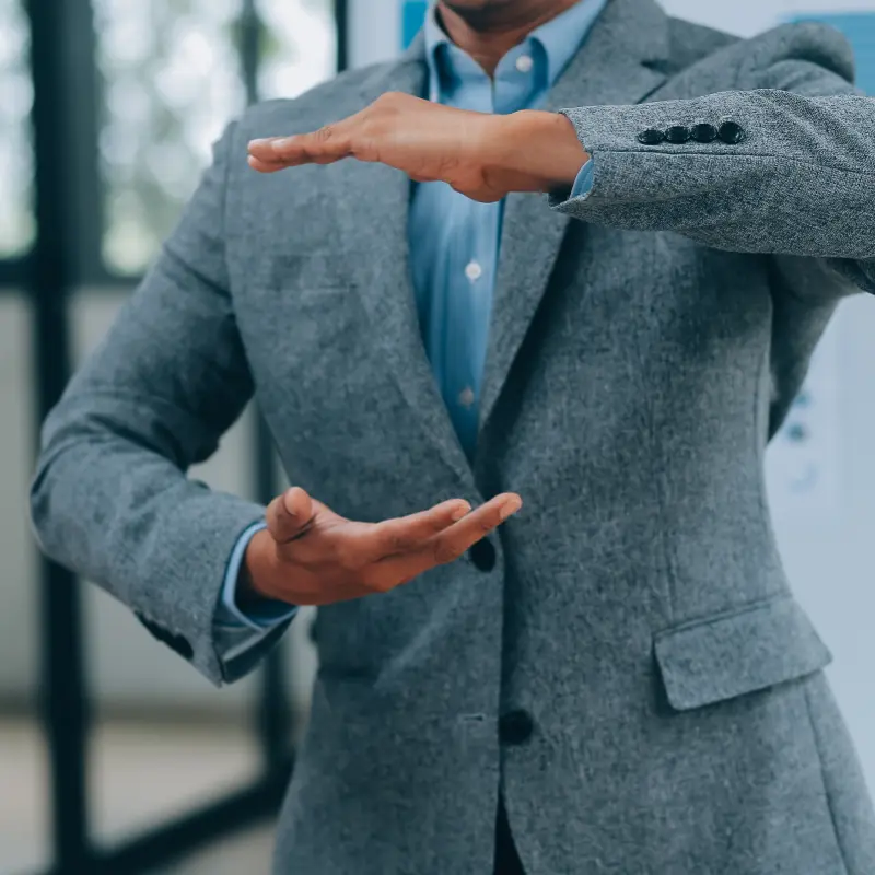 Mann in Anzug bildet mit den Händen einen Abstand